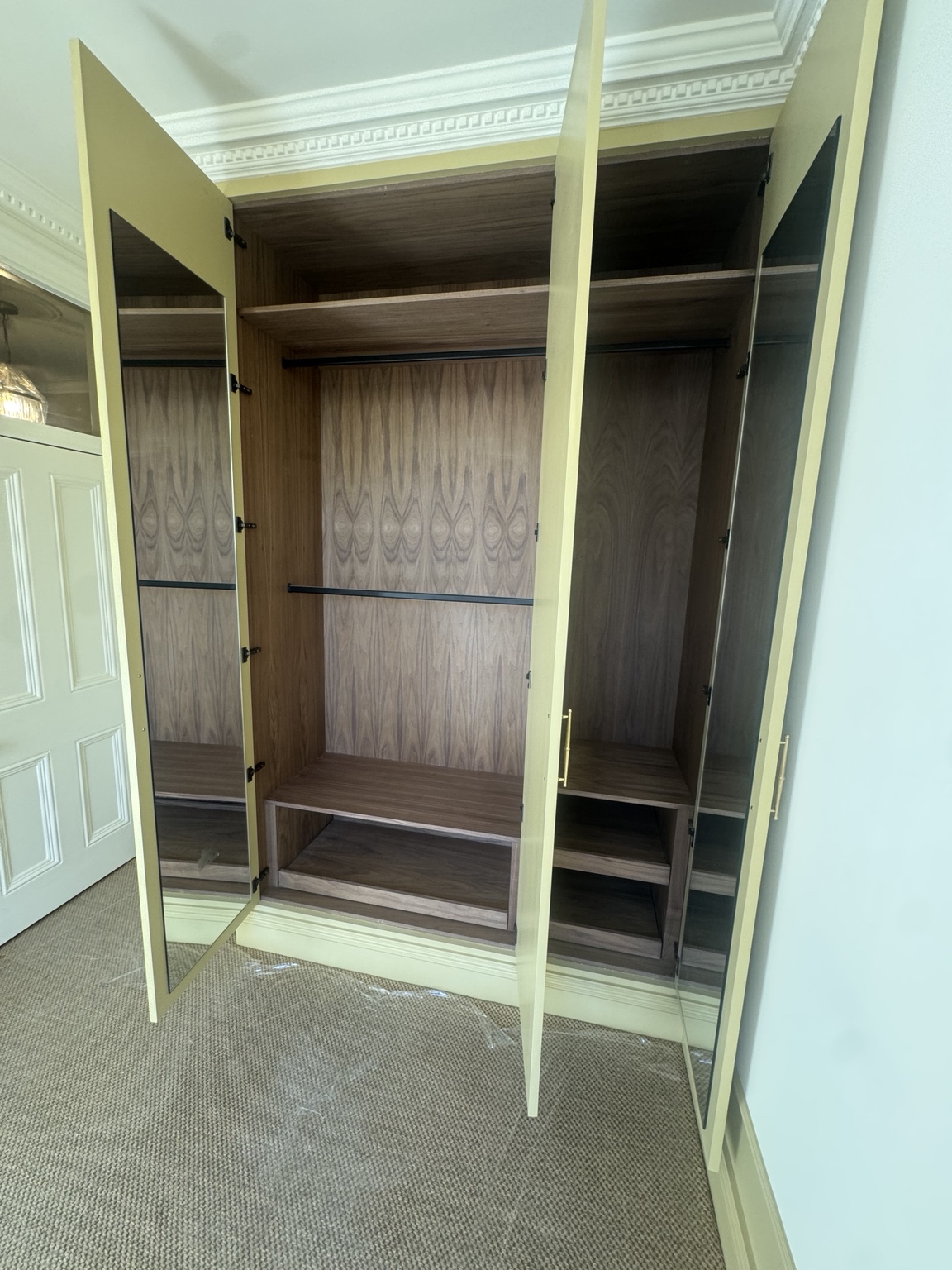 Bedroom 2 walnut wardrobe interior with black hanging rails and lower storage