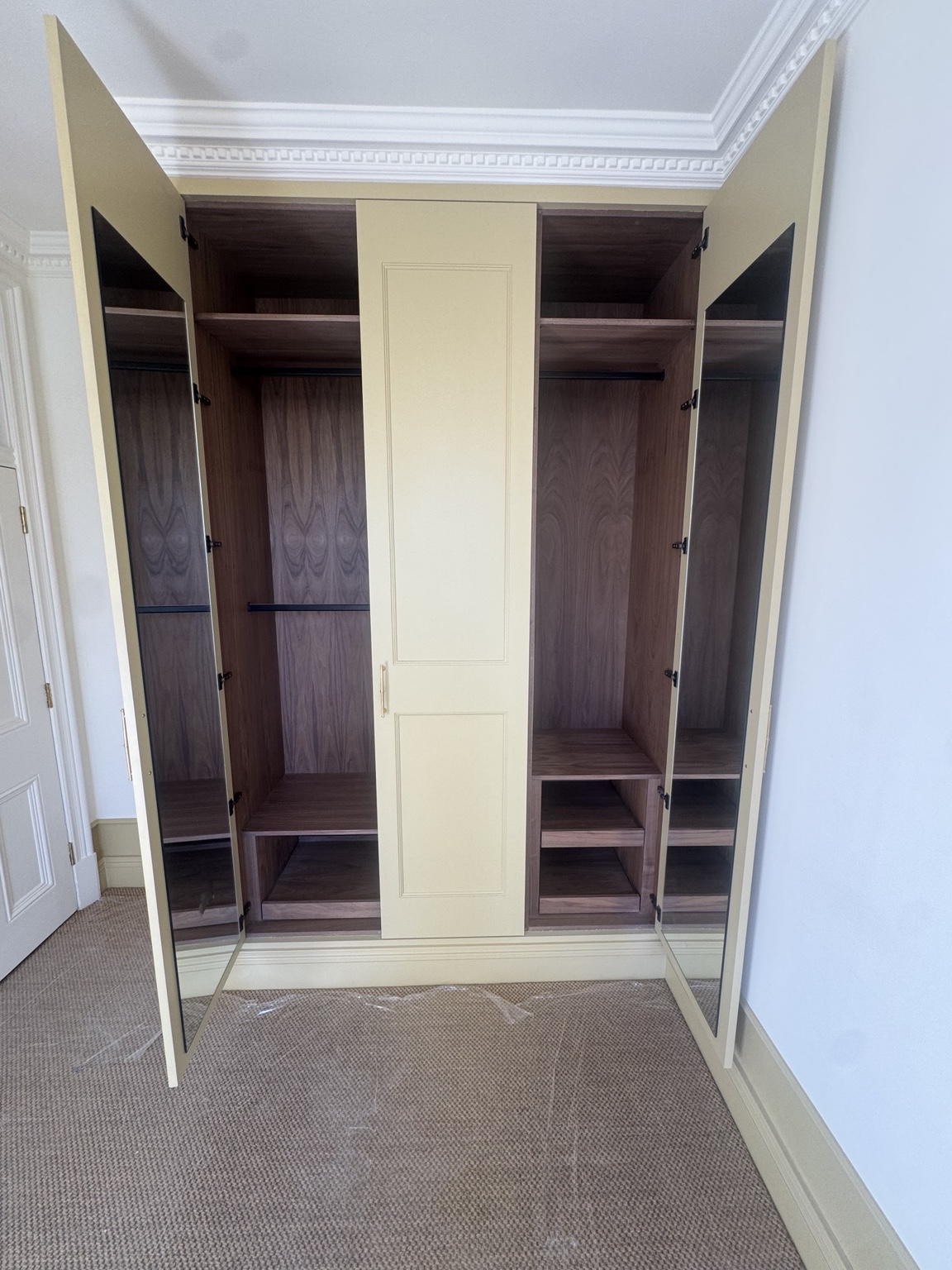Bedroom 2 wardrobe open to show walnut veneer interiors and mirrors on the inner door faces