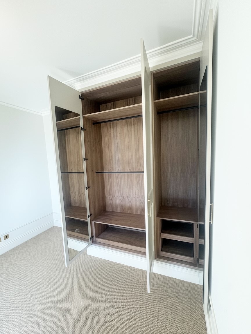 Walnut veneer wardrobe interior with black hanging rails and shelves