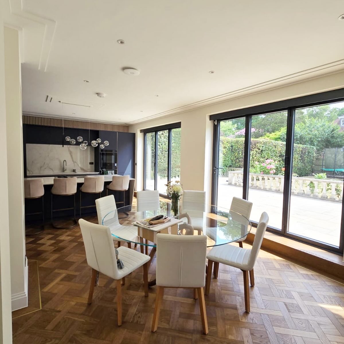 Dining area with garden doors and the bespoke kitchen beyond