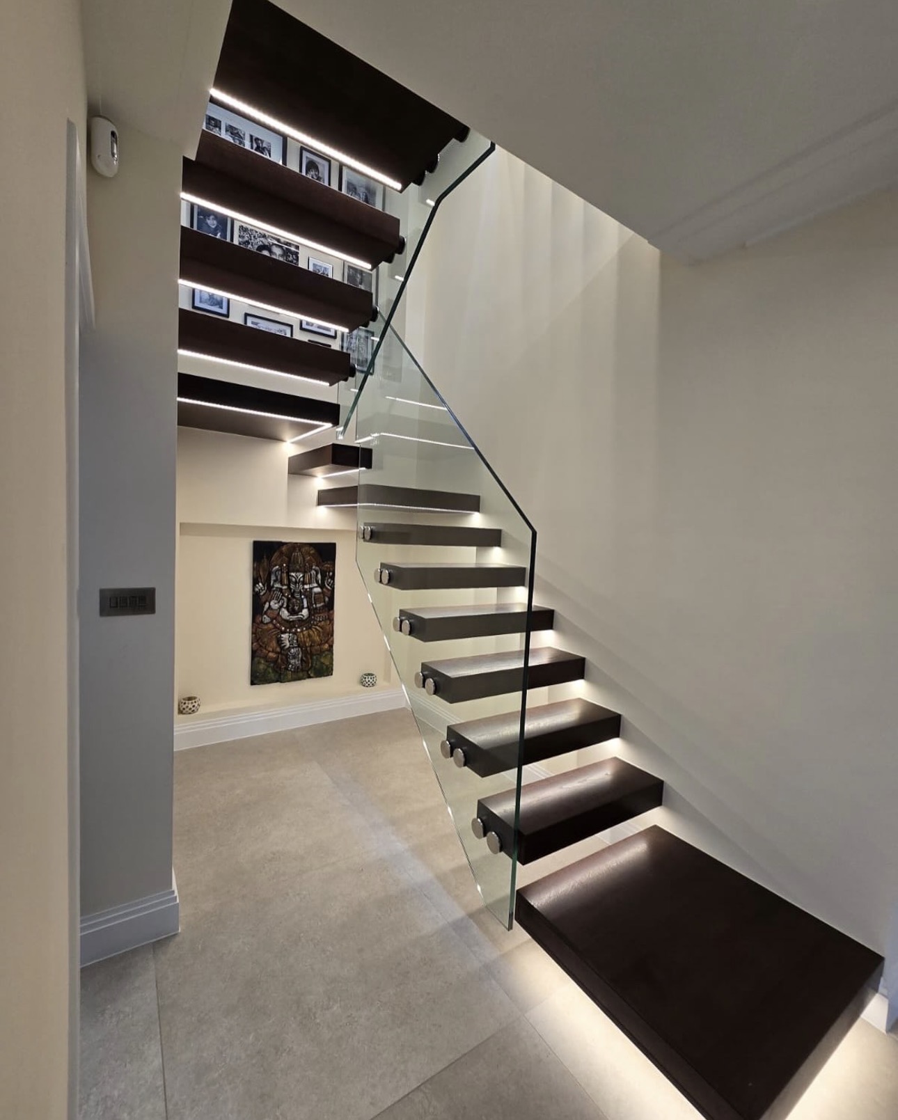 Illuminated floating oak staircase with glass balustrade in Gerrards Cross