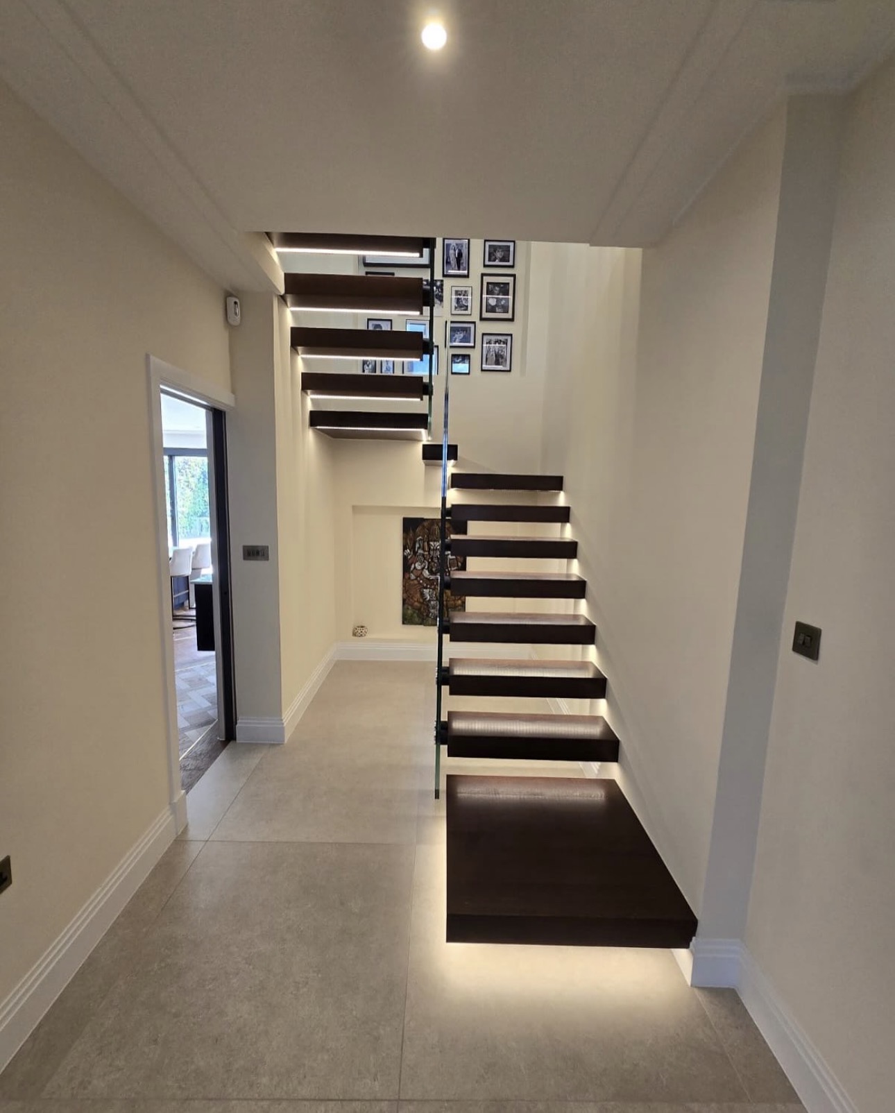 Front view of the floating staircase, illuminated treads and glass balustrade
