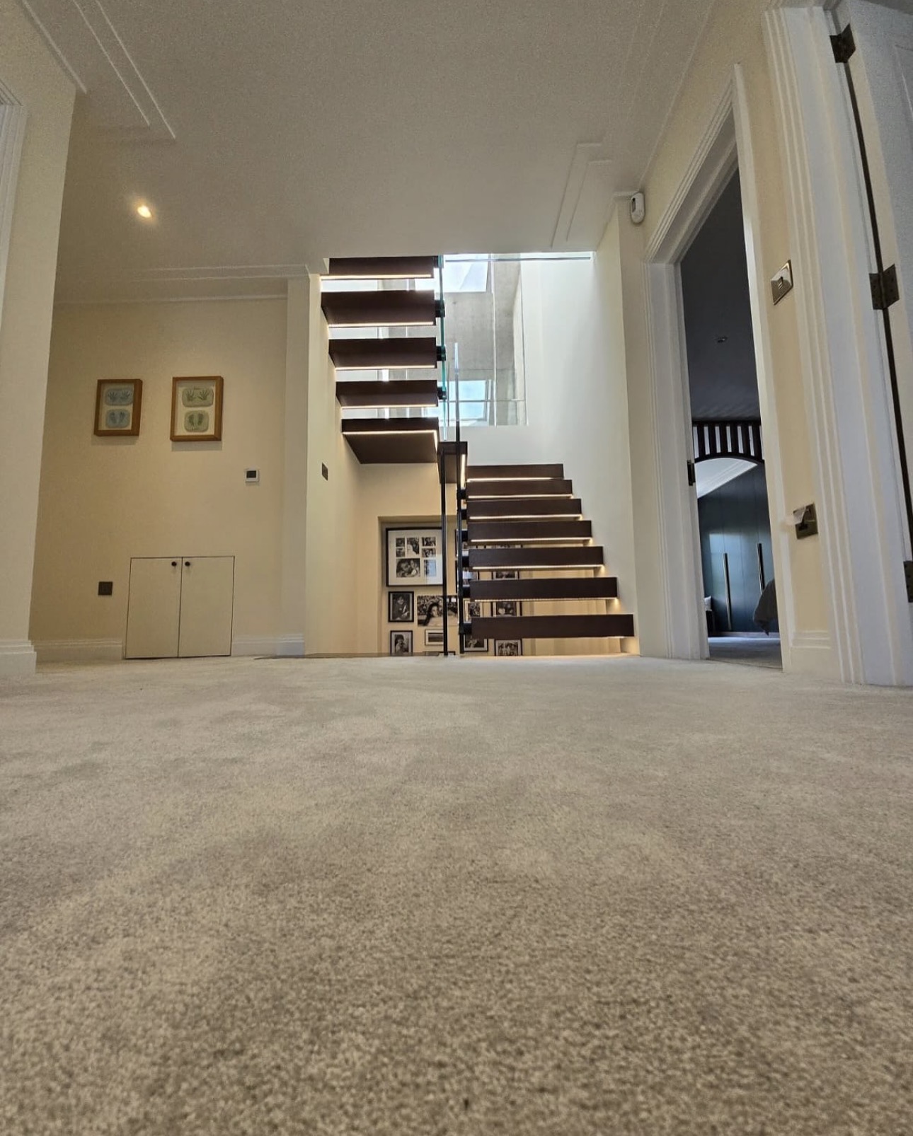 Staircase viewed from the upper landing through a wide hall