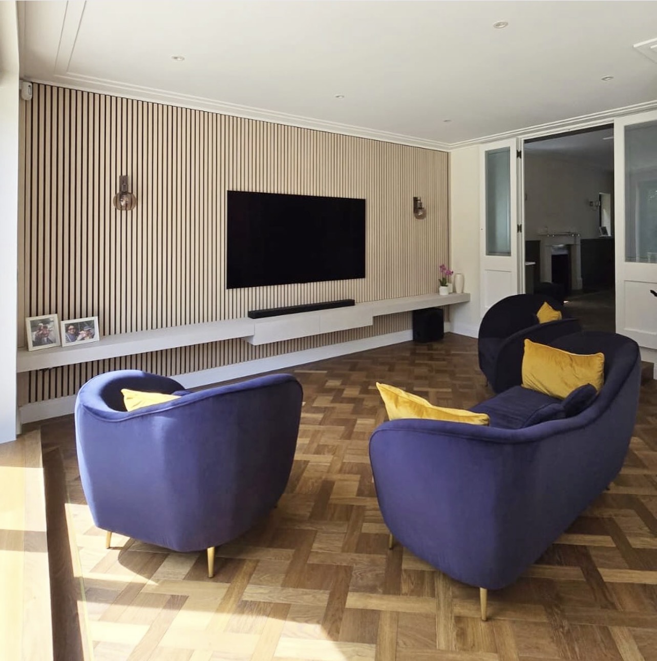 Acoustic panelled media wall and full-width floating shelf in Gerrards Cross