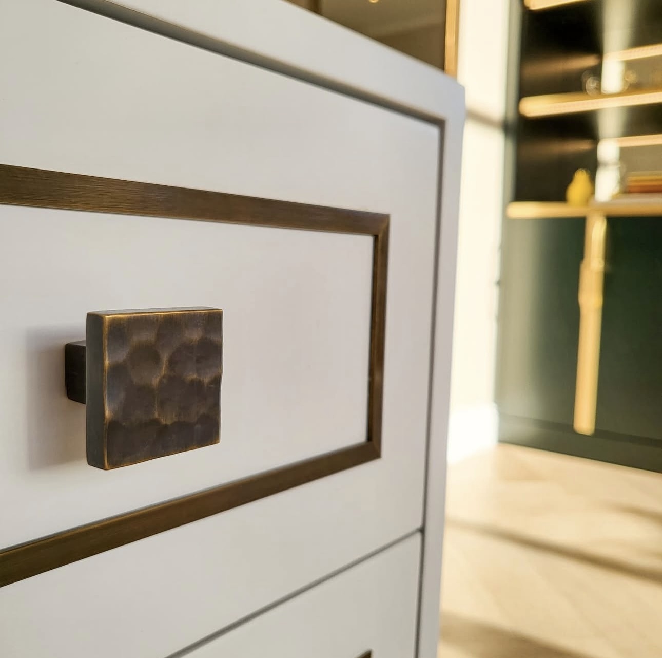Close-up of decorative inlay and a brass-toned handle on bespoke joinery