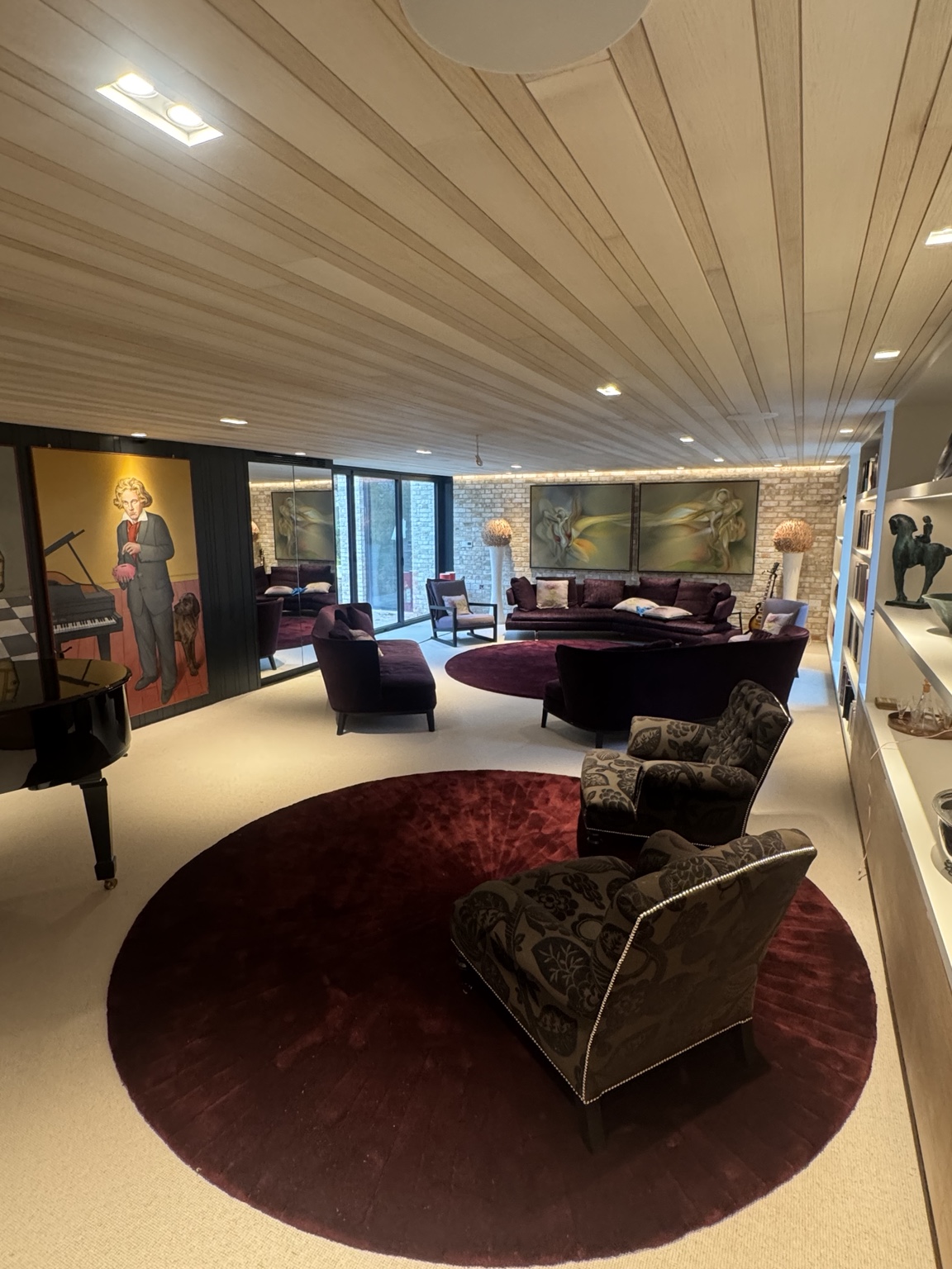 Full view of Marlow music room showing ceiling panelling, seating and mirrored cabinet