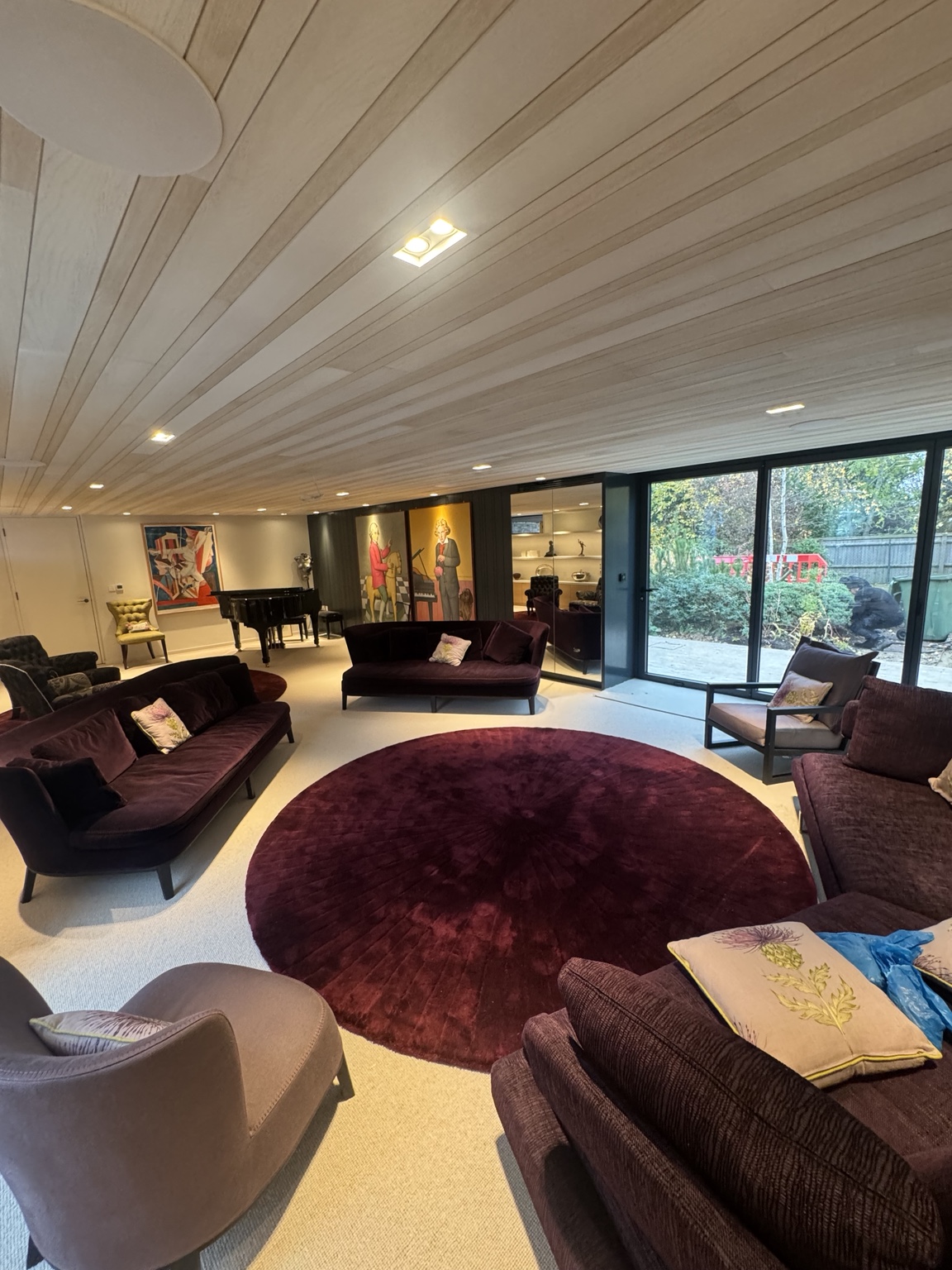 Seating area with oak veneer ceiling panels and glazed doors