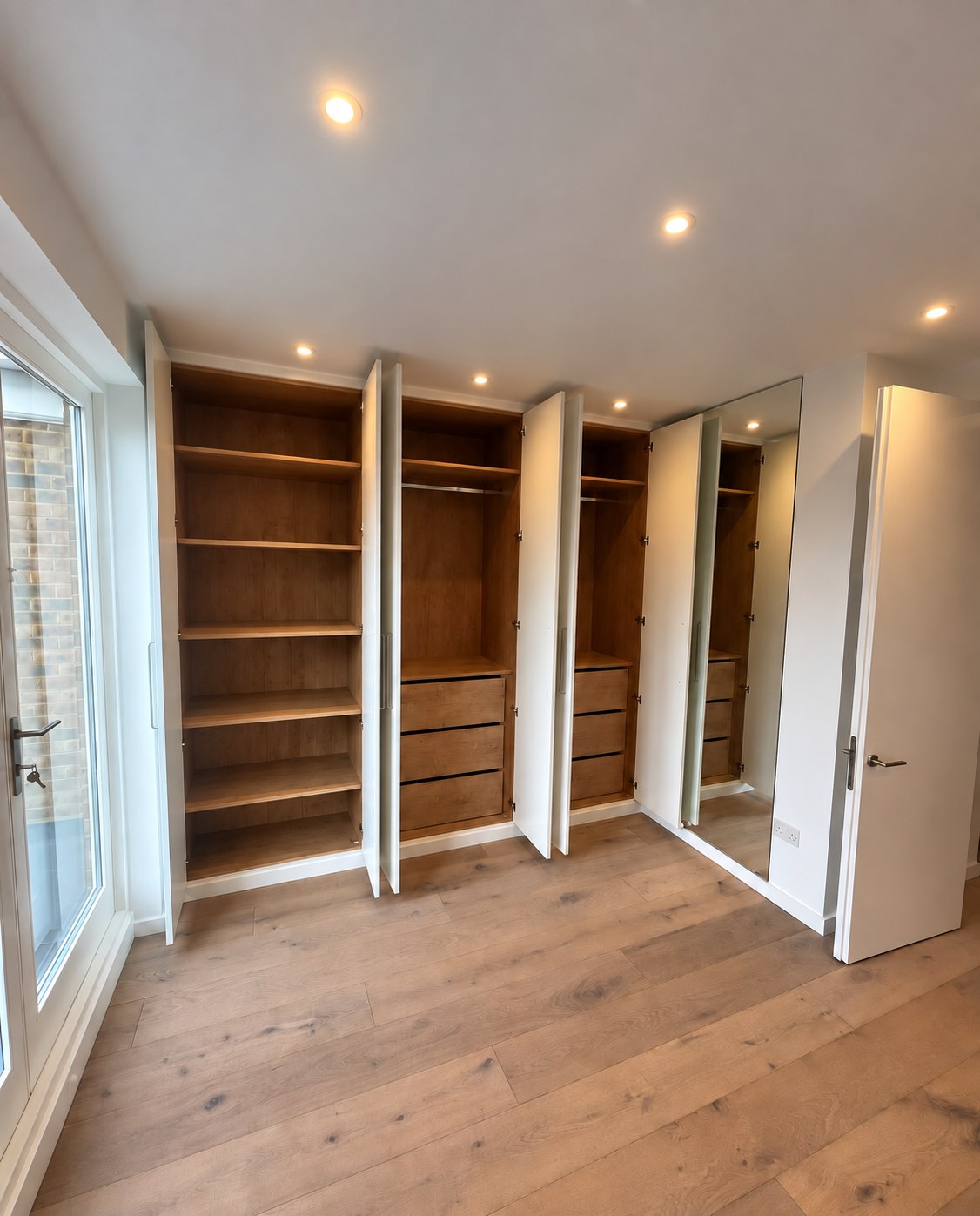 Open triple wardrobe showing truffle brown Denver Oak cabinetry, drawers and shelving
