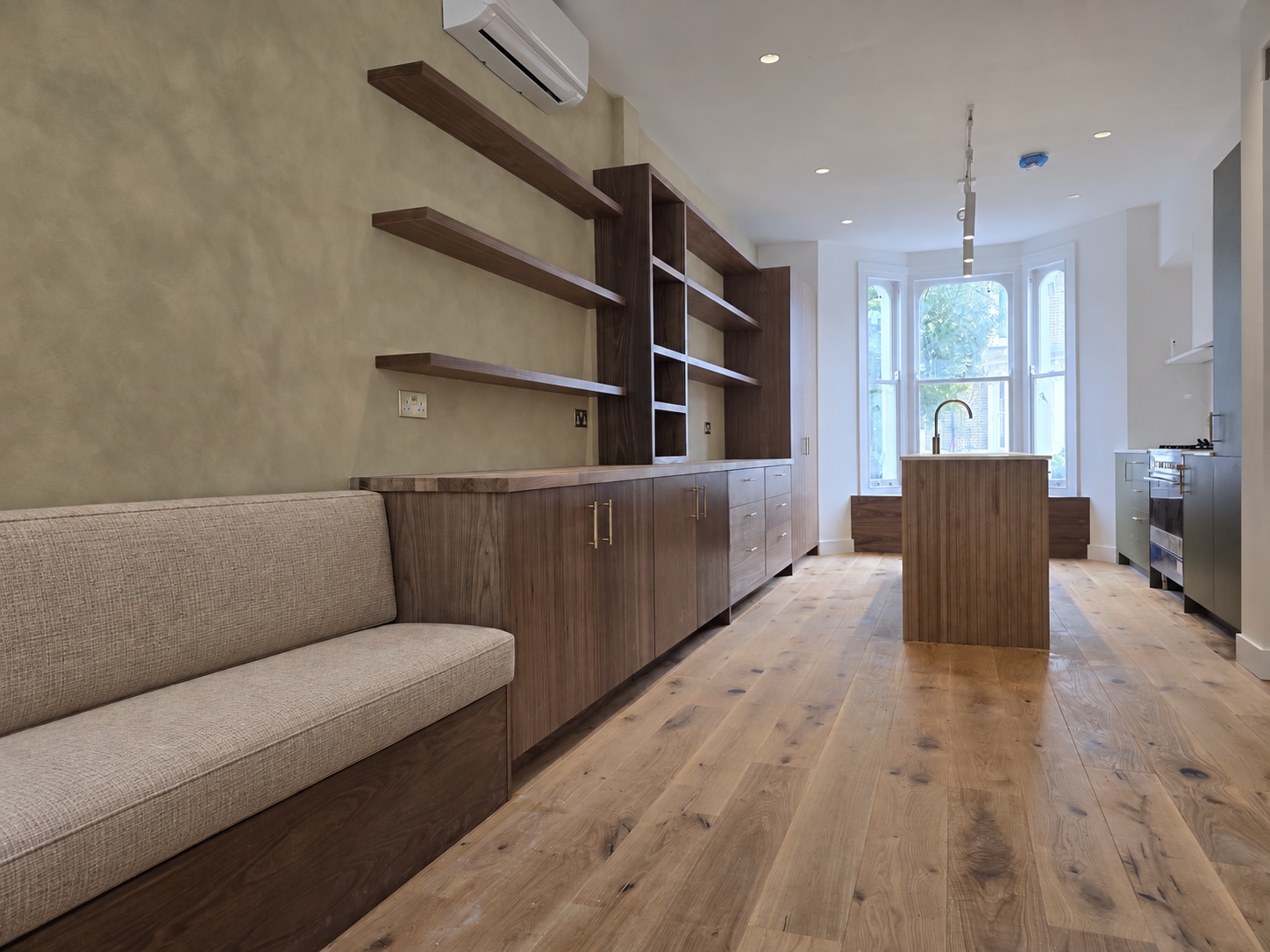 Wide view of the fitted kitchen, oak acoustic island and bench seating