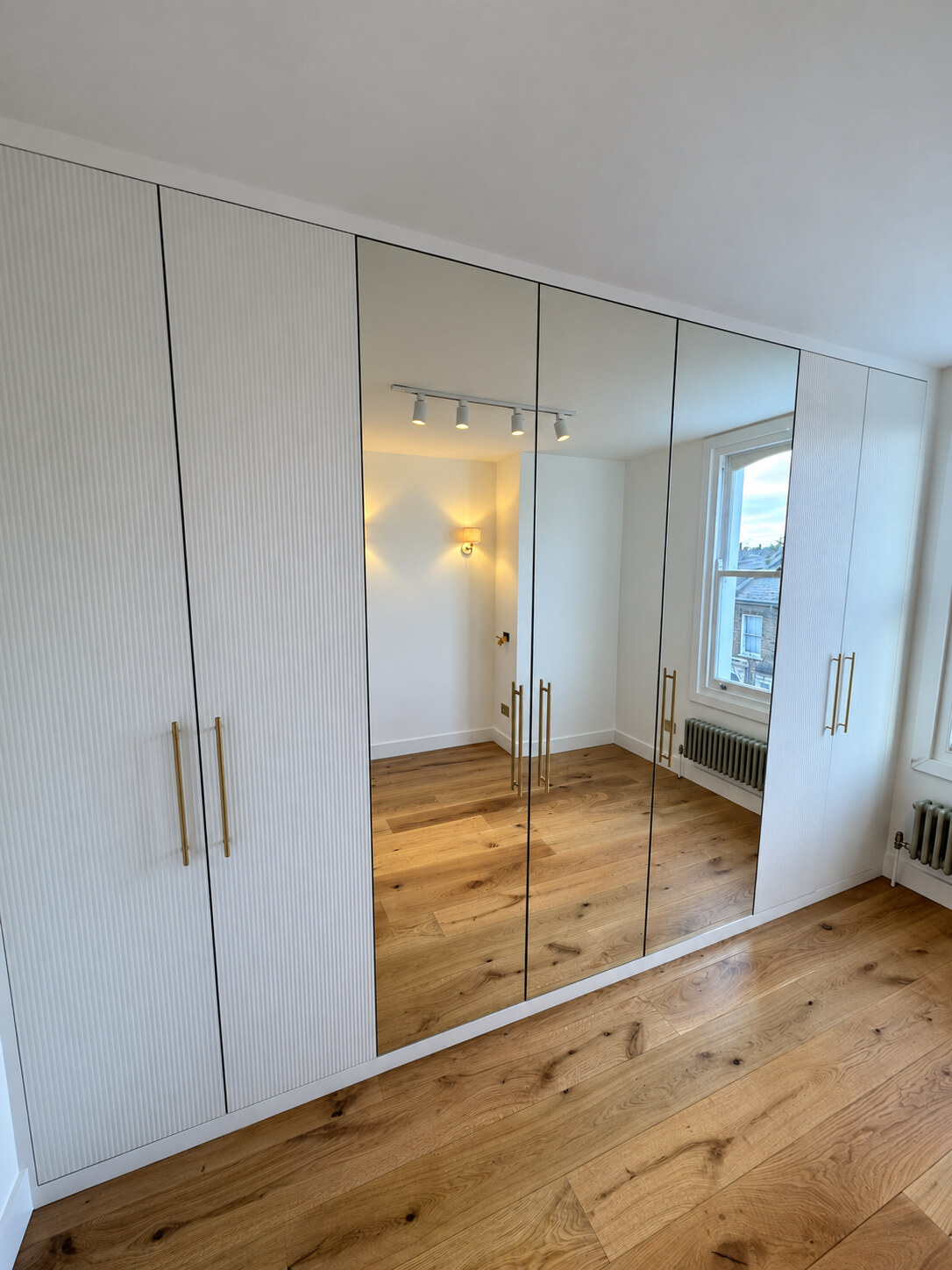 Sprayed ribbed and mirrored wardrobe doors in a Twickenham bedroom