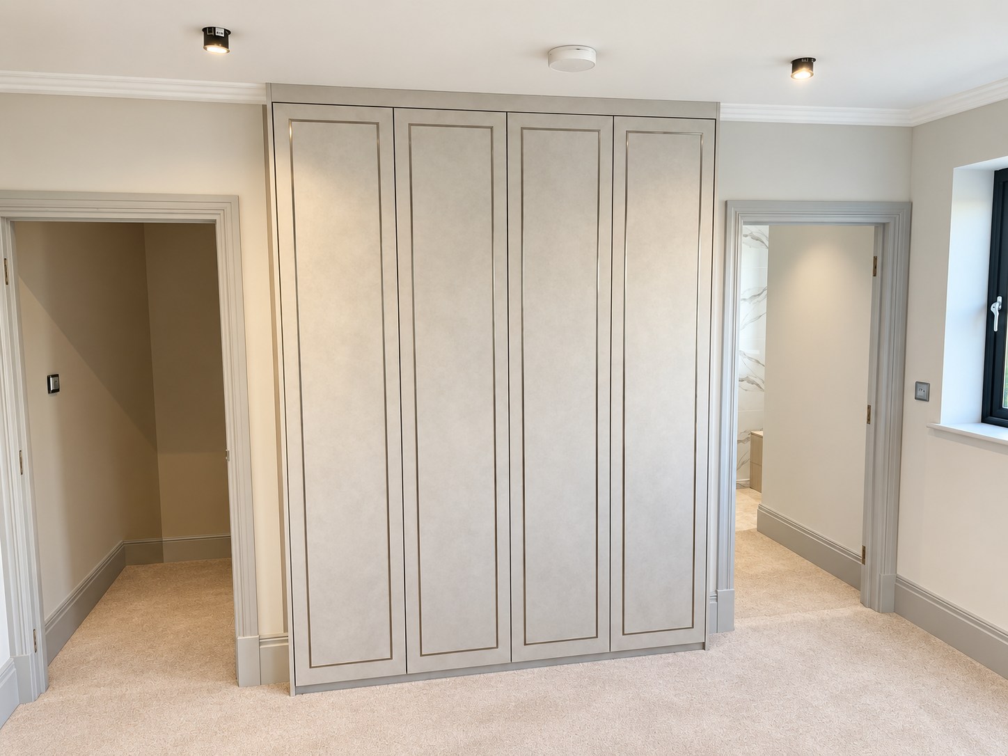 Four fitted wardrobe doors with inlay detail between two doorways