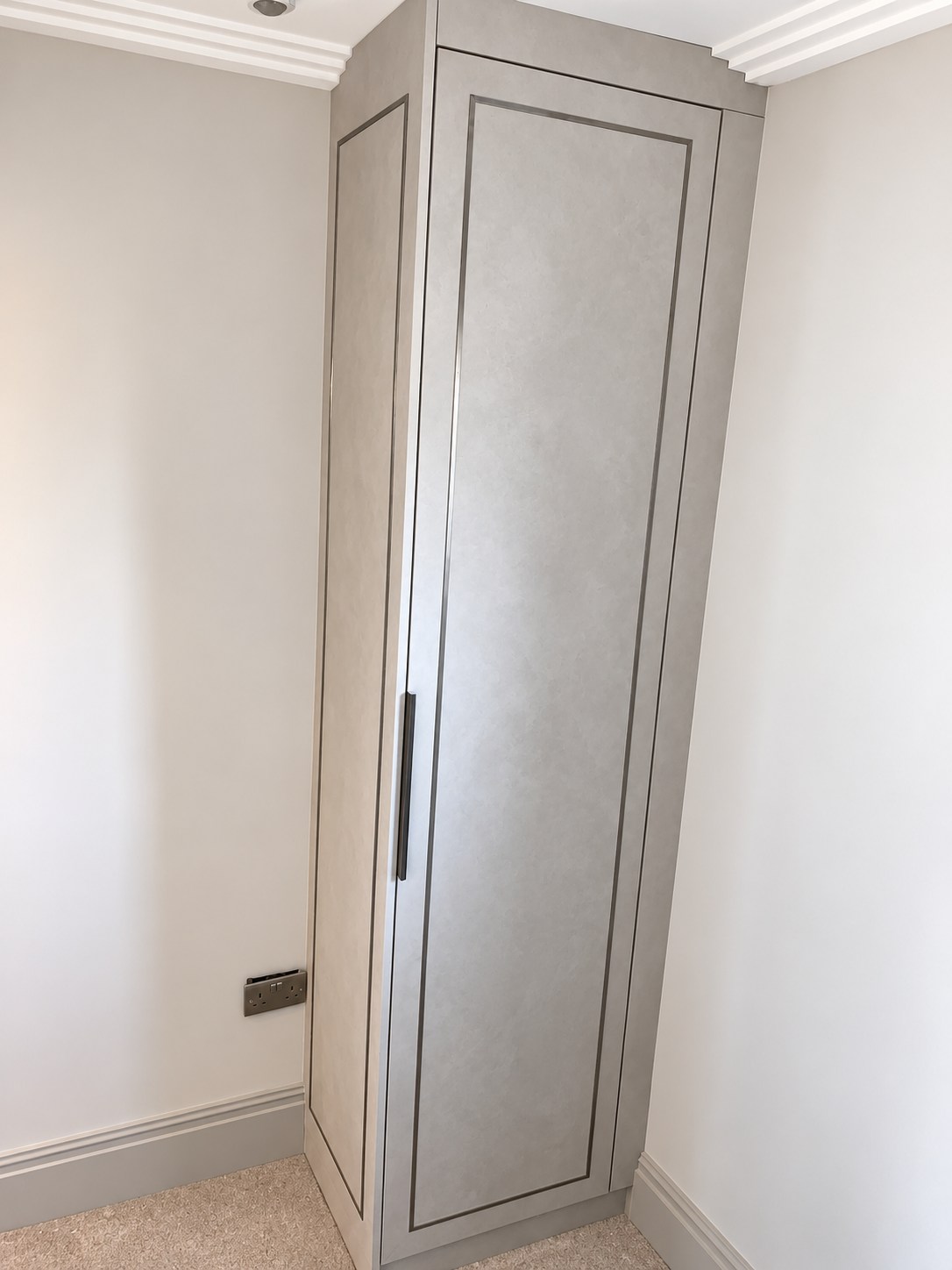 Single fitted wardrobe with inlay-framed door fitted into a corner