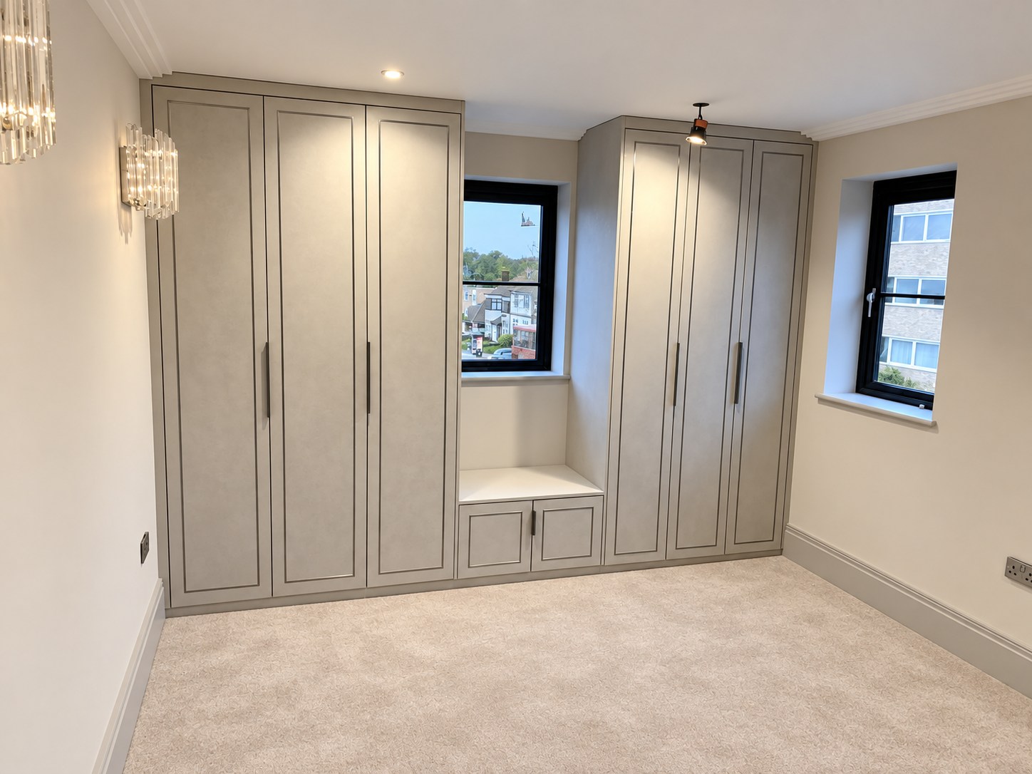 Fitted wardrobes in light grey concrete finish with inlay framed doors and window seat at Wells Lane, Ascot