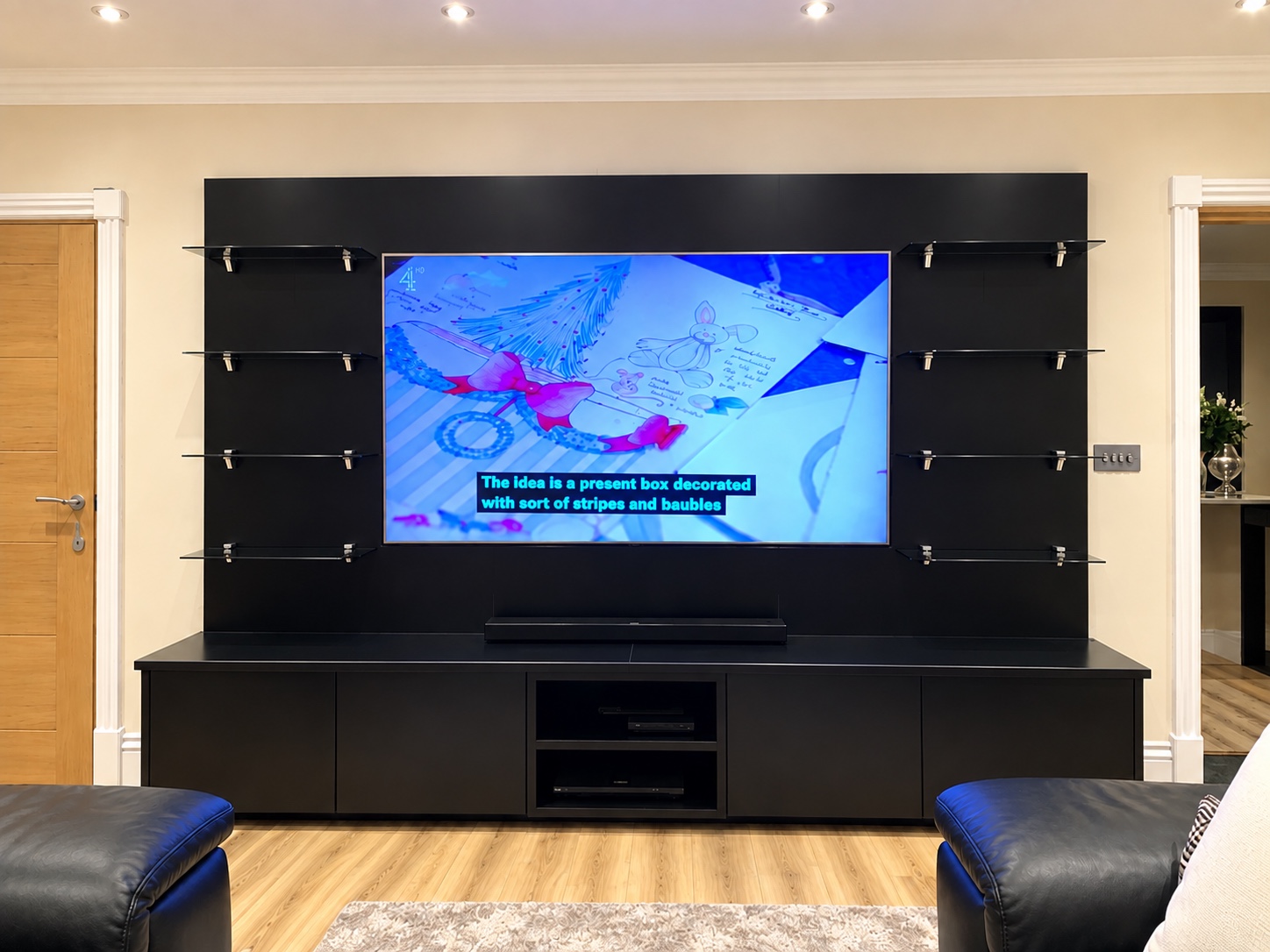 Black sprayed MDF media wall with glass shelves in Ascot