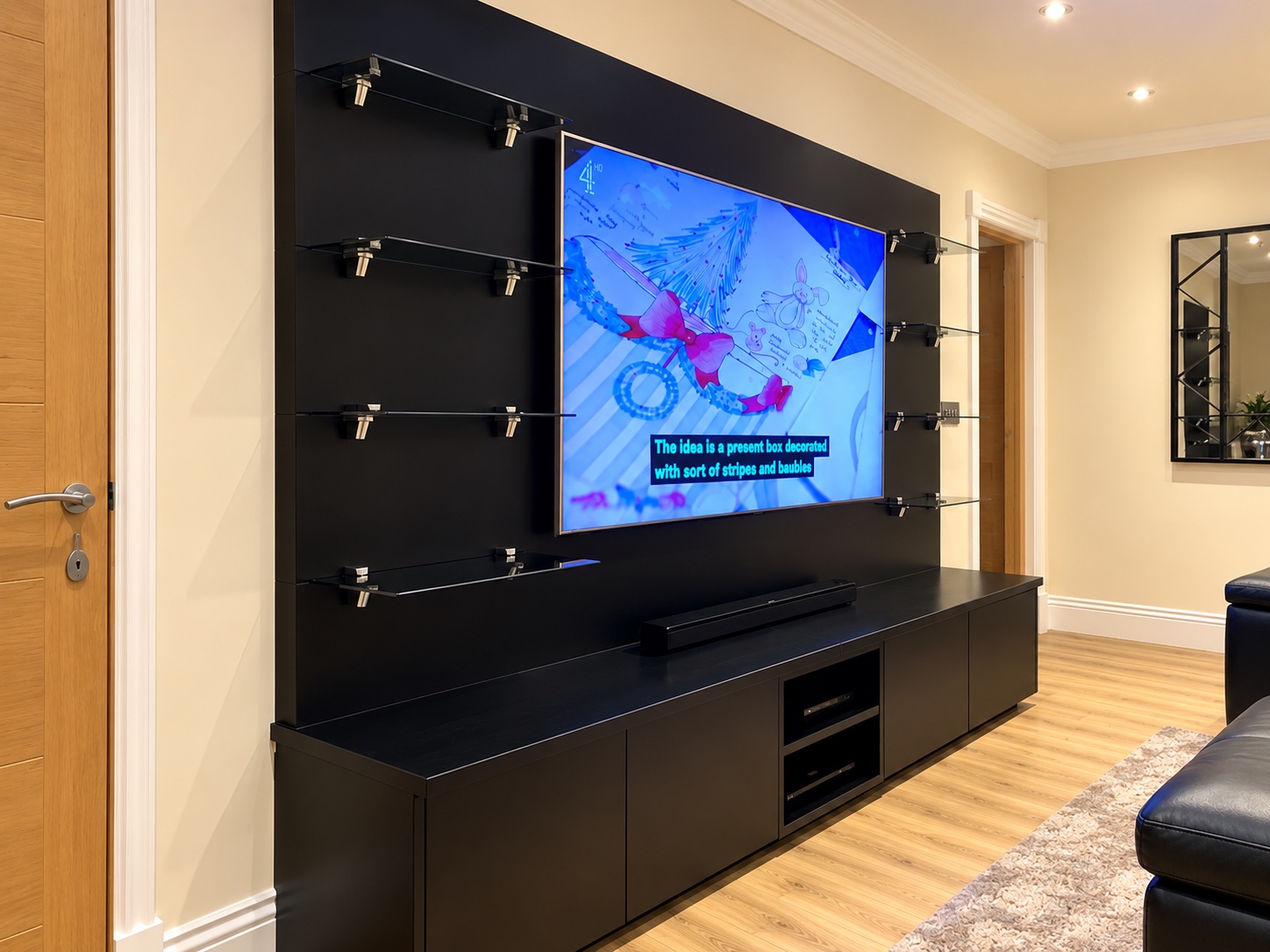 Angled view of the black media wall and storage cabinetry