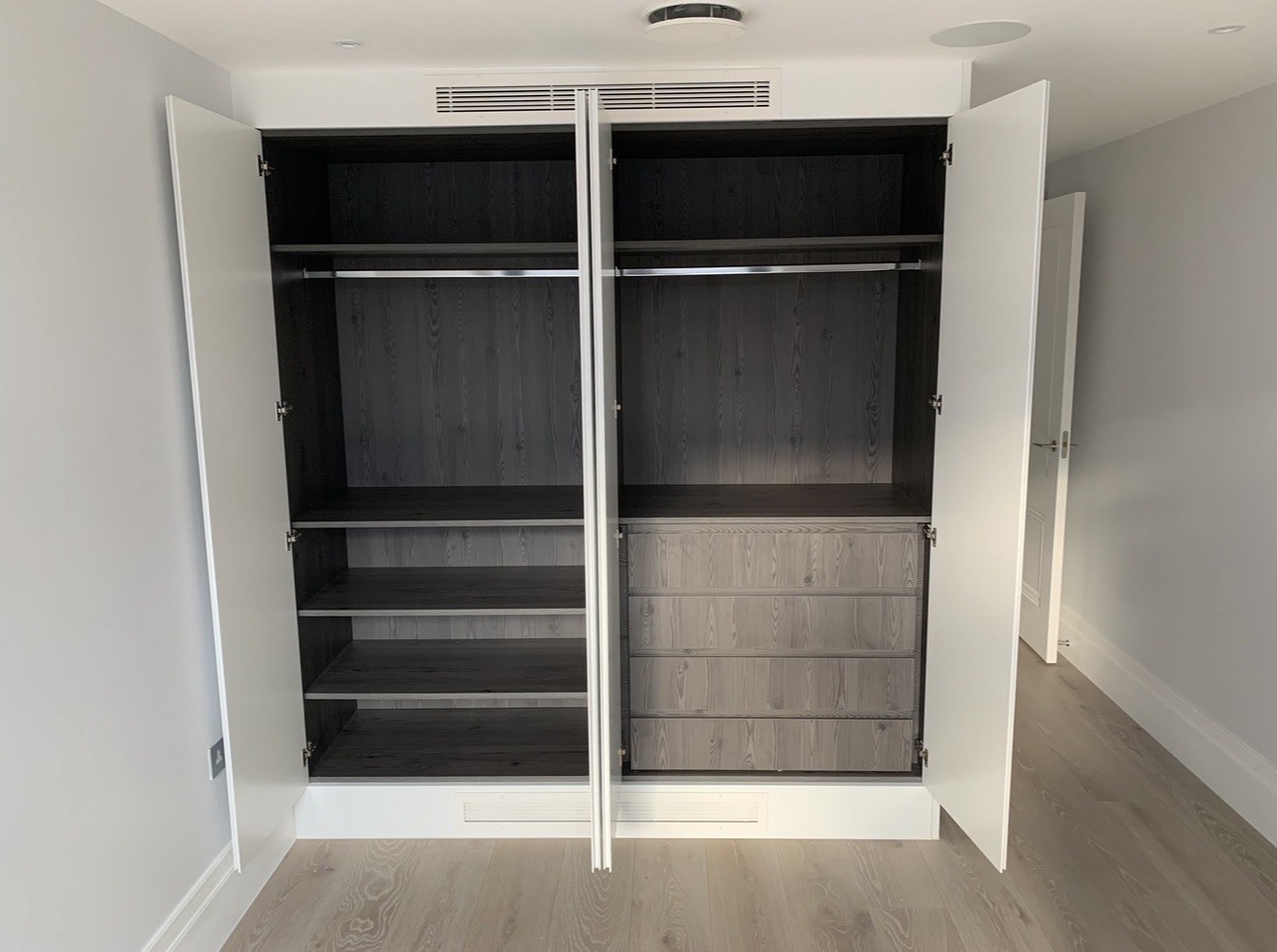 Open double wardrobe with drawer unit, shelves and AC grille above