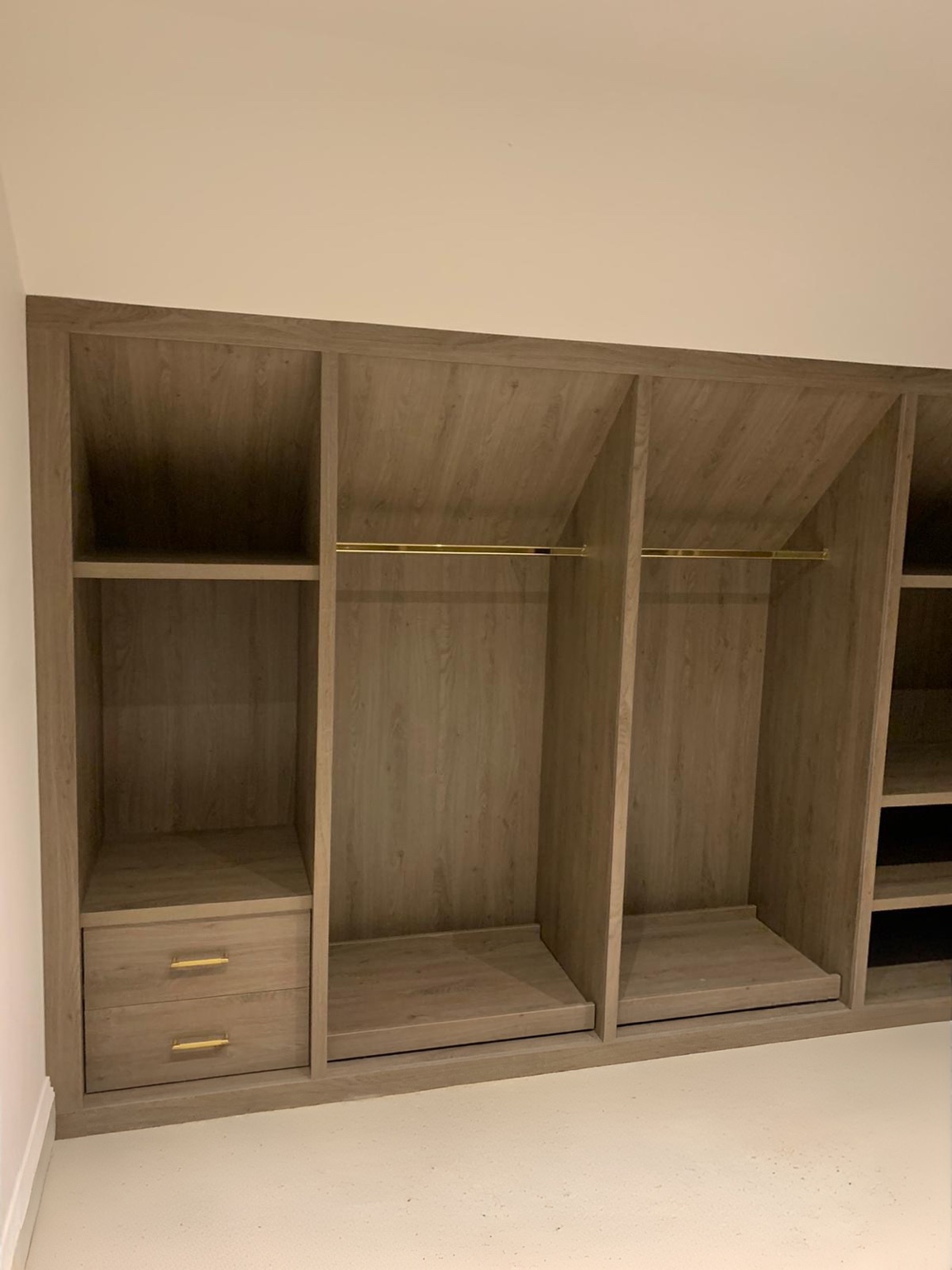 Grey Cordridge Oak MFC hanging spaces and drawers with brass fittings beneath the sloping roof